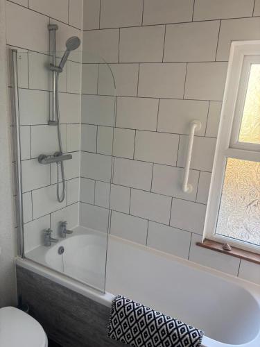 a bathroom with a bath tub with a window at Morecambe Bay Cottage in Morecambe