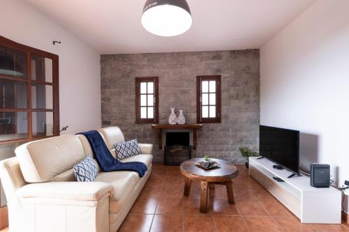 a living room with a couch and a tv at Casa del Mar I by GALMI in Arco de São Jorge