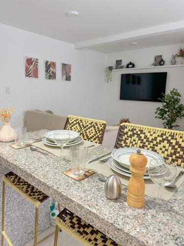 a dining room table with plates and dishes on it at Apartamento NUEVO, moderno e inteligente in Ibagué