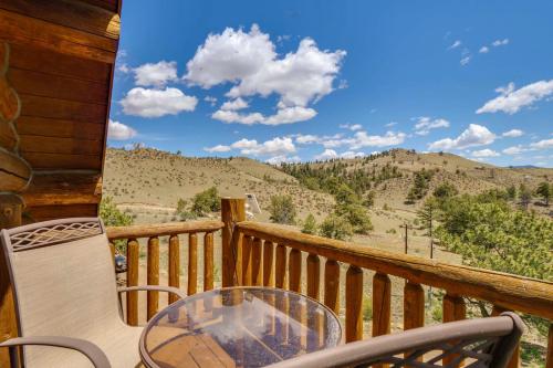 a balcony with a table and chairs on a porch at 24-0089 Rustic Hartsel Getaway with 35-Acre Yard in Fairplay