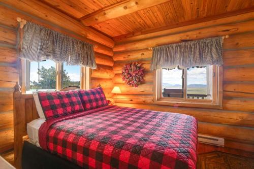 a bedroom with a bed in a log cabin at 24-0089 Rustic Hartsel Getaway with 35-Acre Yard in Fairplay