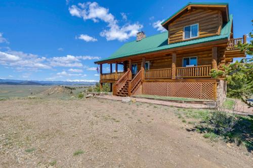 a log cabin with a green roof on a hill at 24-0089 Rustic Hartsel Getaway with 35-Acre Yard in Fairplay