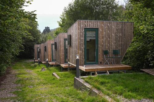 a row of tiny houses sitting in the grass at Green Tiny Village Harz - Sleep Space 32 in Osterode