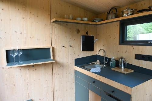 a kitchen with a sink and a counter with a window at Green Tiny Village Harz - Sleep Space 32 in Osterode