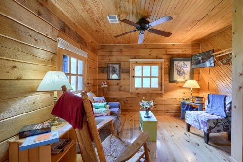a log cabin living room with a ceiling fan at Bison Hollow Hideaway in South Bloomingville