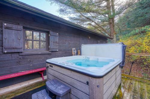 a large bath tub sitting next to a wooden building at Bison Hollow Hideaway in South Bloomingville