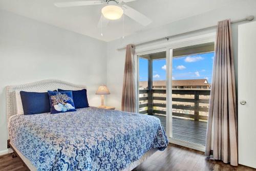 a bedroom with a bed and a large window at Lighthouse Point Rental 2C in Tybee Island