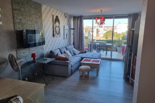 un salon avec un canapé bleu et une table dans l'établissement Naturiste Cap d'Agde Héliopolis C 65, au Cap d'Agde