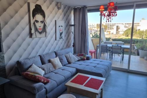 un salon avec un canapé bleu et une table dans l'établissement Naturiste Cap d'Agde Héliopolis C 65, au Cap d'Agde