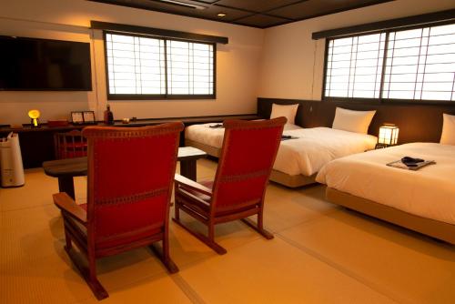 a hotel room with two beds and a table and chairs at Kyoto Takasegawa Bettei - Vacation STAY 69818v in Kyoto