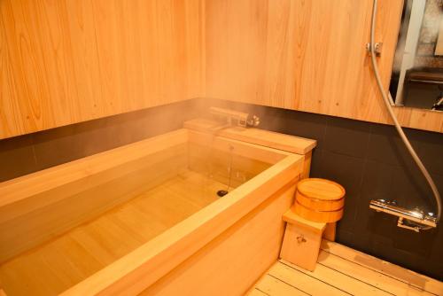 a bathroom with a wooden tub with a toilet at Kyoto Takasegawa Bettei - Vacation STAY 69818v in Kyoto