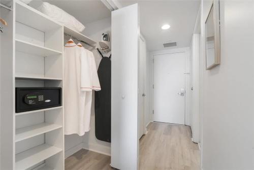 a walk in closet with white cabinets and a door at Amazing Studio with Balcony & Pool in Hallandale Beach