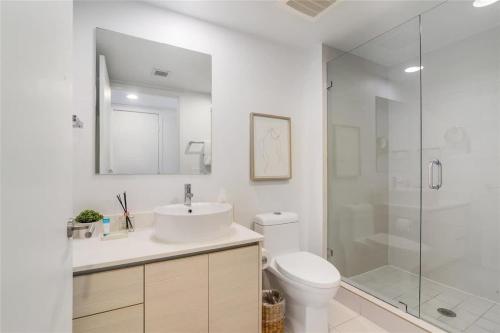 Un baño con inodoro, lavabo y ducha. en Amazing Studio with Balcony & Pool, en Hallandale Beach
