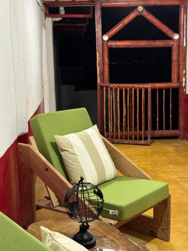 a green chair and a lamp on a porch at Finca La Macarena by Welttisch in Génova