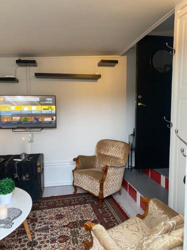 a living room with two chairs and a table at Solsidan 1 in Karlstad