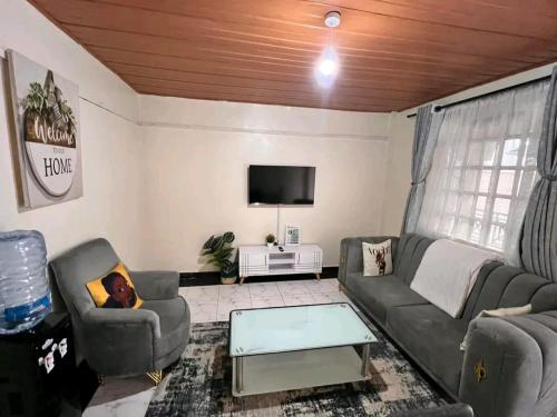 a living room with a couch and chairs and a tv at Affordable Studio - WIFI, Netflix & Parking in Kikuyu