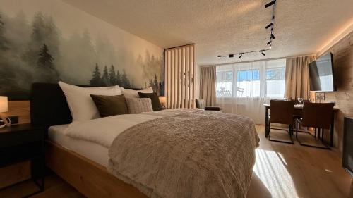 Un dormitorio con cama, escritorio y televisión. en WALDNEST - Apartment Seefeld, en Seefeld in Tirol