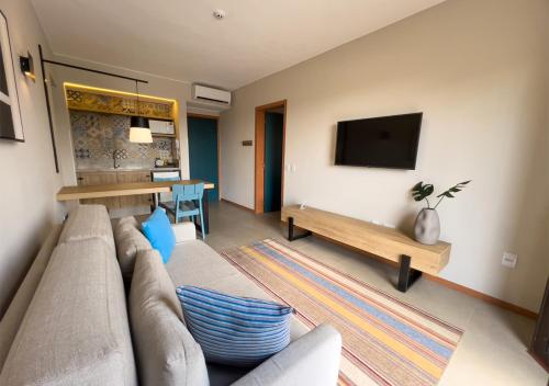 a living room with a couch and a flat screen tv at Resort Quinta Santa Barbara in Pirenópolis