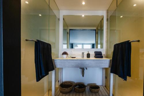 a bathroom with a sink and a mirror and baskets at Loft 44 puebla center by Rotamundos in Puebla
