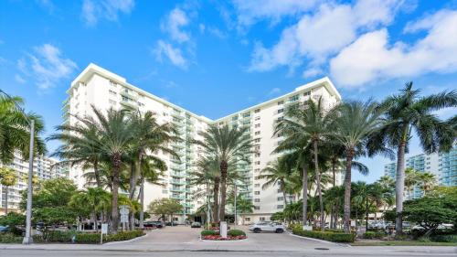 a large white building with palm trees in front of it at The Tides Ocean Luxury Suites in Hollywood