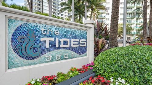 a sign for the tides with flowers in front of a building at The Tides Ocean Luxury Suites in Hollywood