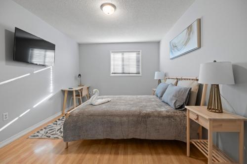 a bedroom with a bed and a table with a lamp at Happy Life in Barrie