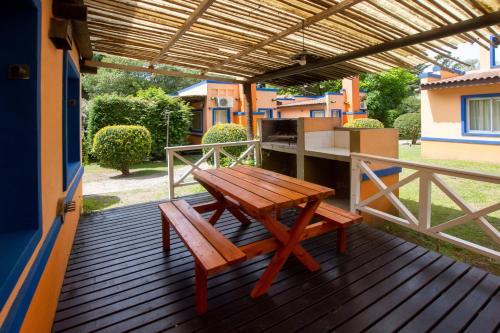 a wooden deck with a table and a bench at Complejo Viva Zapata in Mar de las Pampas