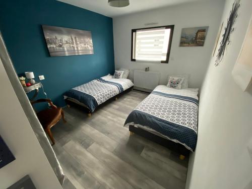 two beds in a room with blue walls at Maison Koh Tao - Chambre chez l habitant - in Langueux