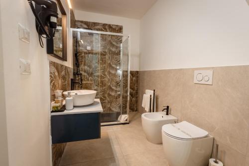 a bathroom with a toilet and a sink and a shower at Etnea Boutique Hotel in Catania