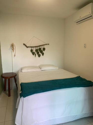 ein Schlafzimmer mit einem weißen Bett mit grüner Bettwäsche in der Unterkunft Chalé Park Mar, São José e Maragogi in São José da Coroa Grande