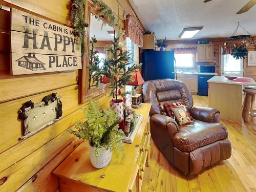 a living room with a leather chair and a happy place sign at Mountain Mist in Sevierville