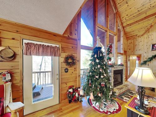 a living room with a christmas tree in a cabin at Mountain Mist in Sevierville