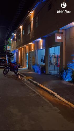 a motorcycle parked in front of a building at night at Hotel Lima in Barra do Turvo