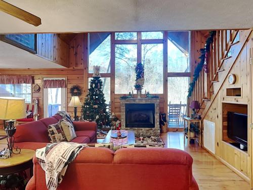 a living room with a red couch and a christmas tree at Mountain Mist in Sevierville