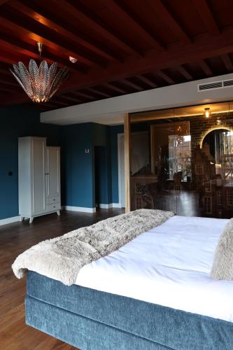 a bedroom with a large white bed in a room at Stadshotel Geertruidenberg in Geertruidenberg