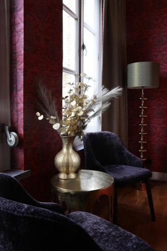 a room with two chairs and a vase on a table at Stadshotel Geertruidenberg in Geertruidenberg