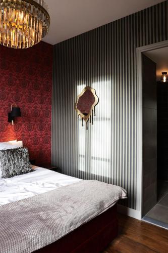 a bedroom with a bed and a red wall at Stadshotel Geertruidenberg in Geertruidenberg