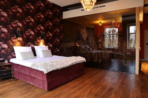 a bedroom with a bed and a wall with flowers at Stadshotel Geertruidenberg in Geertruidenberg