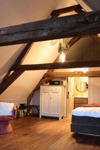 a attic room with a bed and a kitchen at Stadshotel Geertruidenberg in Geertruidenberg