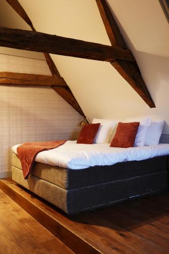 a bedroom with a large bed in a attic at Stadshotel Geertruidenberg in Geertruidenberg