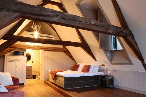 a room with a couch and a tv in a attic at Stadshotel Geertruidenberg in Geertruidenberg