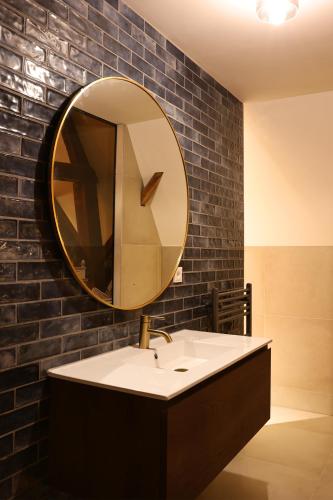 a bathroom with a sink and a mirror on a brick wall at Stadshotel Geertruidenberg in Geertruidenberg