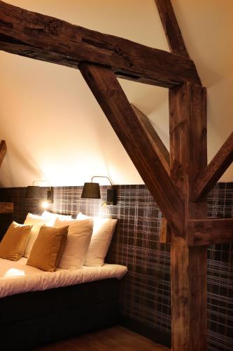 a bed in a room with wooden beams at Stadshotel Geertruidenberg in Geertruidenberg