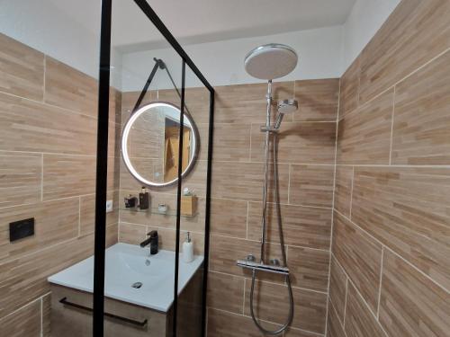 une salle de bain avec une douche, un lavabo et un miroir dans l'établissement Lumineux appt 2 chambres sur les hauteurs de Briançon, terrasse et garage, à Briançon