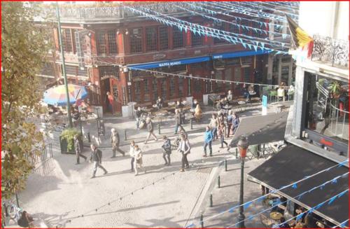 a group of people walking down a city street at Heart of Brussels Escape, Steps from Bourse in Brussels