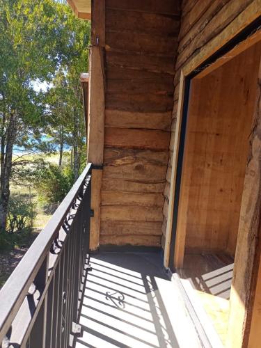 an outside door of a wooden house with a porch at La pincoya in Chonchi