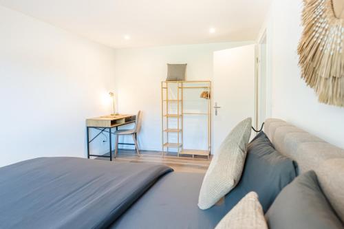 a bedroom with a couch and a desk and a table at Cute & cozy oasis, private afternoon sun terrace in Kandersteg