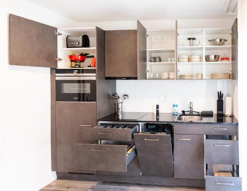 a kitchen with stainless steel appliances and cabinets at Cute & cozy oasis, private afternoon sun terrace in Kandersteg