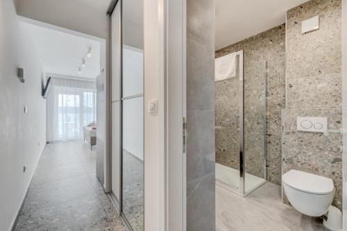 a bathroom with a toilet and a walk in shower at Deluxe Seaview Studios KENNEDY II in Mimice