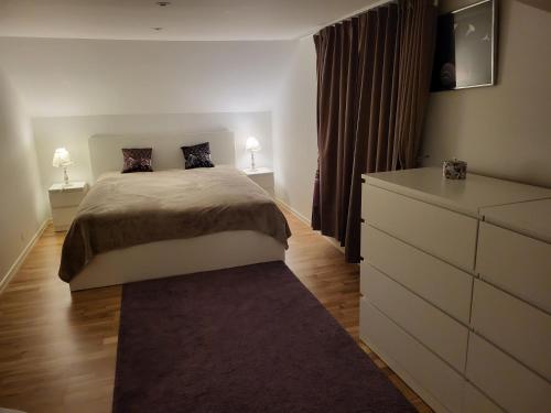 a bedroom with a bed and a dresser with two lamps at Sahlin - Kattarp in Kattarp